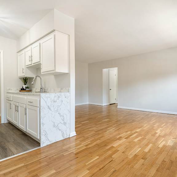 a kitchen with white cabinets and a stove and black refrigerator