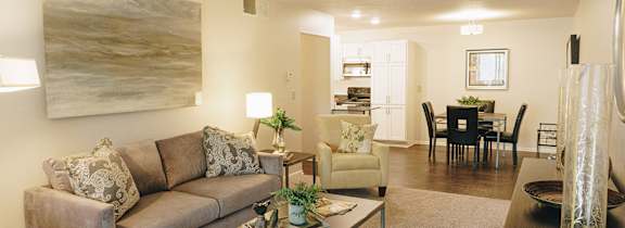 A living room with a brown couch and a glass coffee table. at Astor Place of Edina Apartments , Minnesota