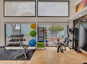 A gym with treadmills, exercise bikes, and weights.