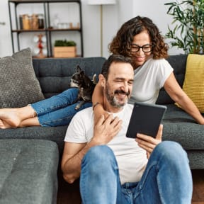 Couple on couch looking at tablet