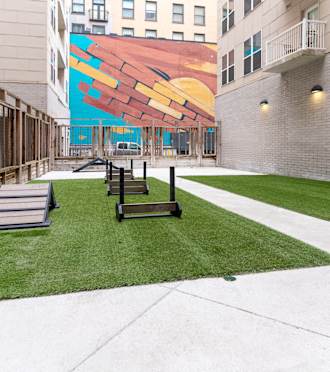 a courtyard with benches and a mural on the side of a building