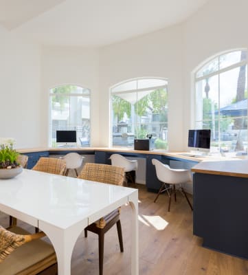 an office with a long white table and wicker chairs