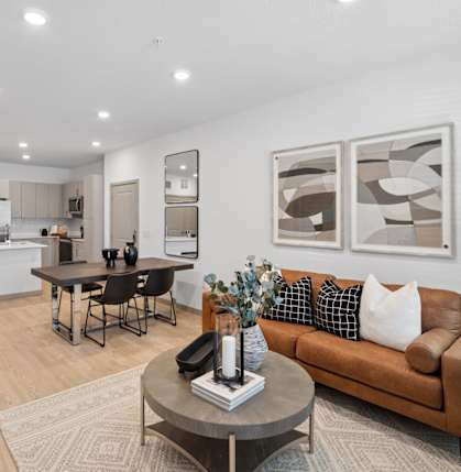 A modern living room with a brown sofa and a coffee table.