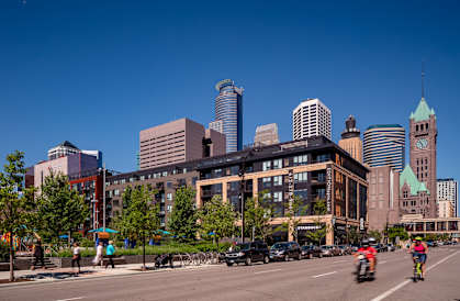 The street view with cars and pedestrians in the foreground at Edition Apartments. 