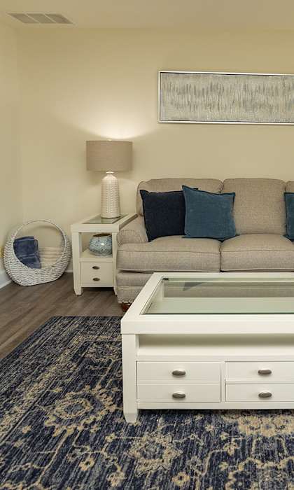 A living room with a couch, a coffee table, and a rug. at The Brittany Apartments, Pikesville, MD, 21208
