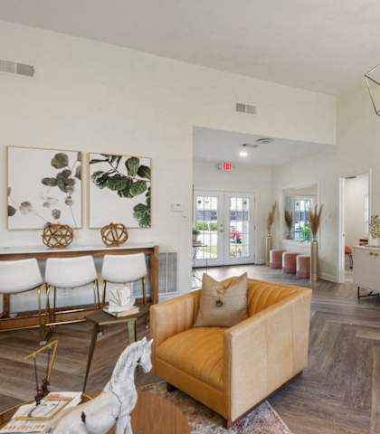 A living room with a yellow sofa and a wooden table. at Timber at the Bay, Gulfport, MS, 39507