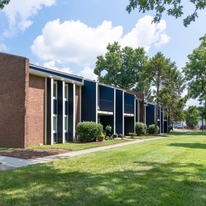 the exterior of a building with grass and trees