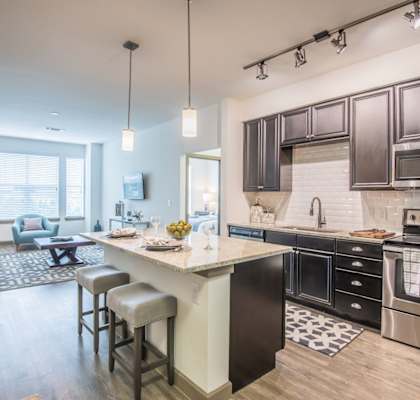 A modern kitchen with dark brown cabinets and a white island.