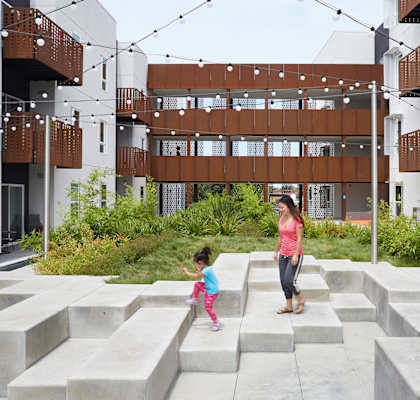 a woman and a child walking down a set of stairs in front of a building