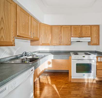 A kitchen with wooden cabinets and a stove top oven.