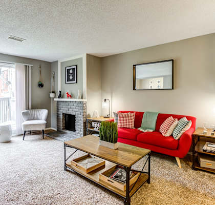 a living room with a red couch and a fireplace