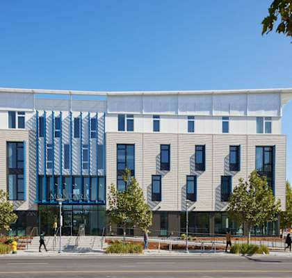 A modern building with a white facade and blue glass windows.