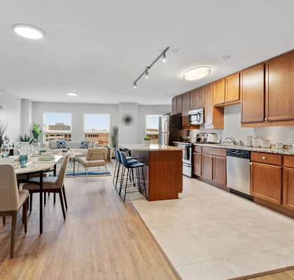 A modern kitchen with wooden cabinets and a dining table.