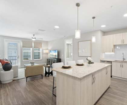 a white kitchen and living room with a table and chairs