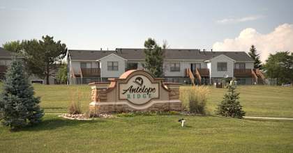 the sign is in the middle of a field in front of an apartment building  at Antelope Ridge, Box Elder, SD, 57719