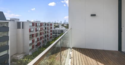 a view of the city from the balcony of a modern apartment