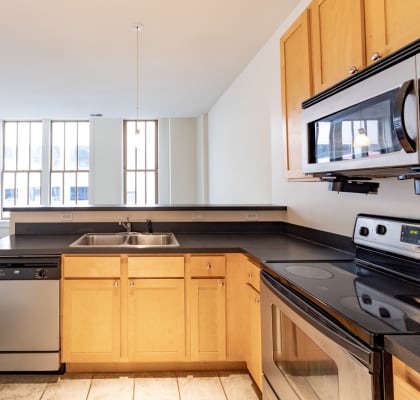 a kitchen with black countertops and white walls at 26 West, Managed by Buckingham Urban Living, 26 West Washington Street, IN