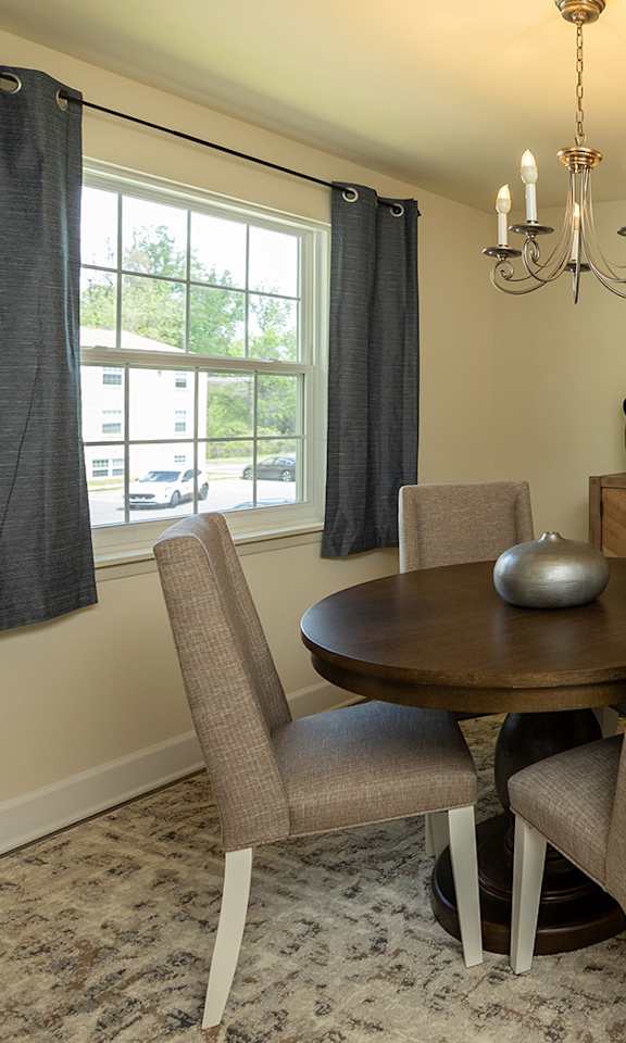 A dining room with a round table and chairs at The Brittany Apartments, Pikesville, MD, 21208