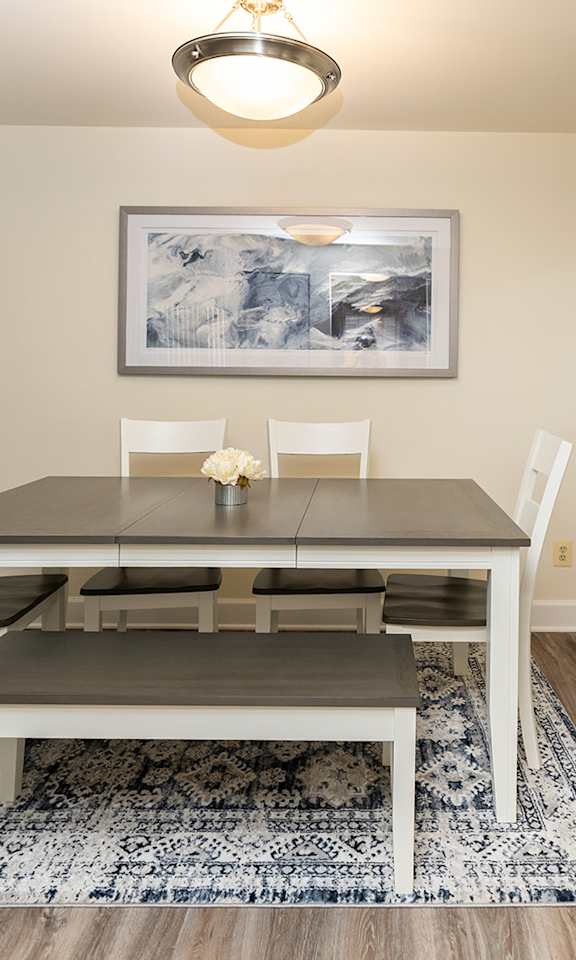 A dining room with a table and chairs.