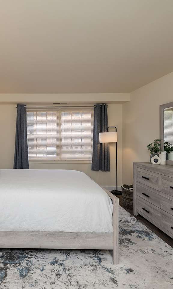 A bedroom with a large bed, nightstands, and a rug.