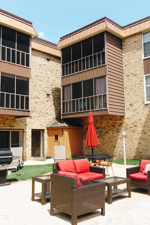 A small pool in a backyard with a house in the background. at Astor Place of Edina Apartments , Minnesota