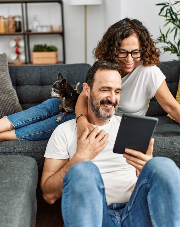 Couple on the couch looking at tablet