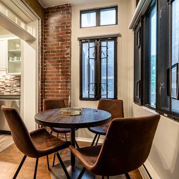 a dining room with a table and chairs next to a kitchen