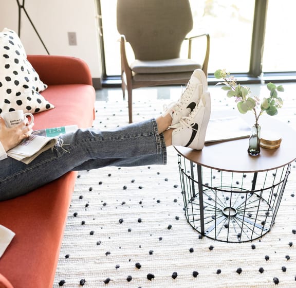 a woman sitting on a couch with her feet up on a coffee table