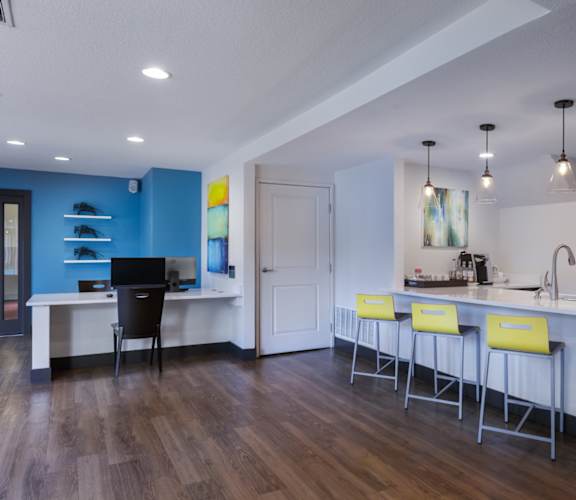 A kitchen with a bar area and a desk with a computer.