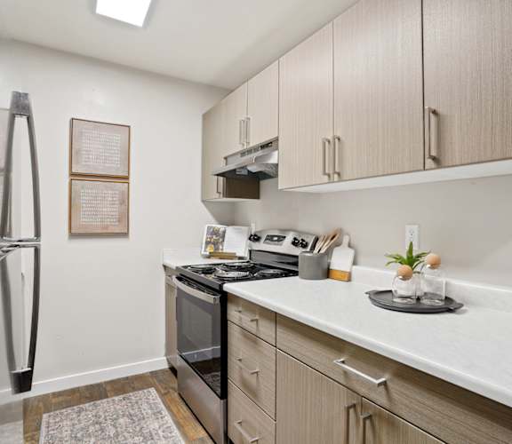 a kitchen with white countertops and wooden cabinets