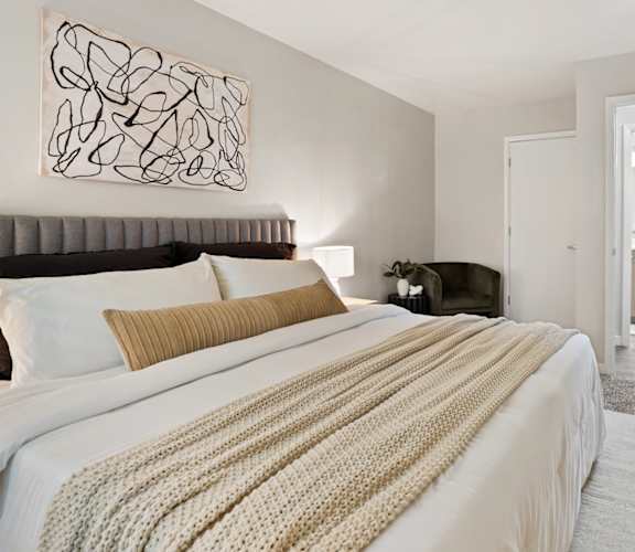 a bedroom with a bed and a chair in a room