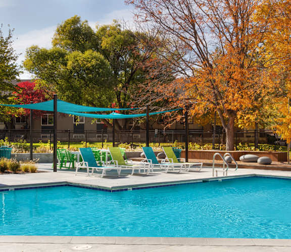 a swimming pool with chaise lounge chairs and umbrellas