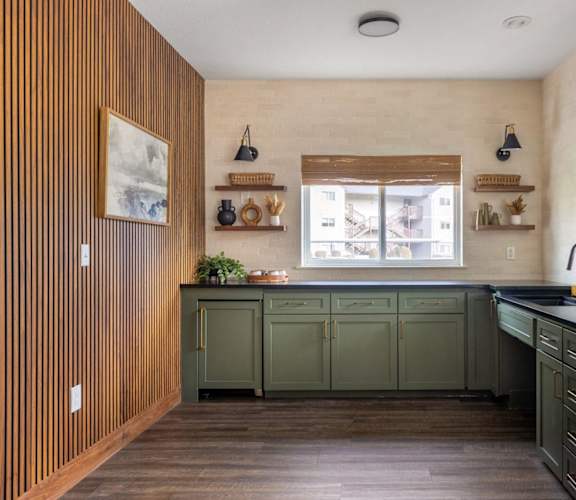 a kitchen with green cabinets and a window