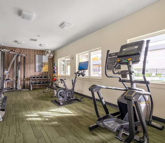 a gym with exercise equipment and mirrors on the wall