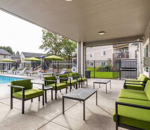 the preserve at cardinal woods pool and patio area with green furniture and umbrellas