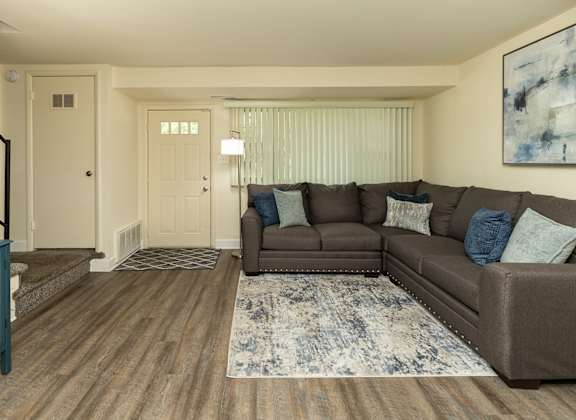 a bedroom with a bed with a green headboard and two night stands with lamps at The Orchards at Severn Townhomes*, Severn