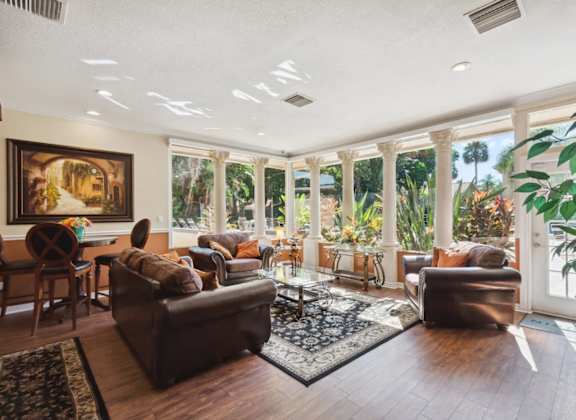 A living room with brown leather couches and a painting on the wall.
