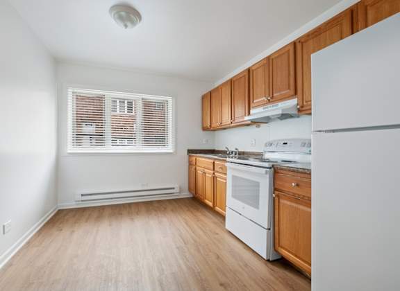A kitchen with wooden cabinets and white appliances.