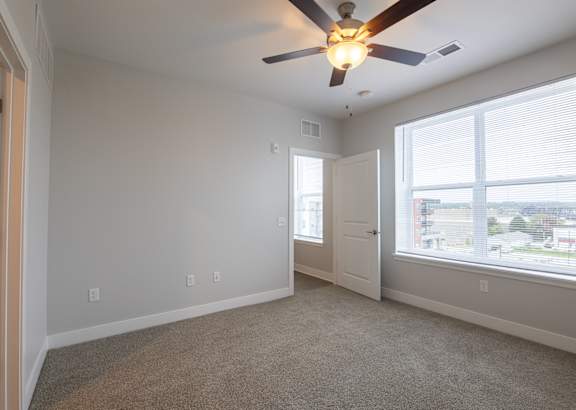 A room with a ceiling fan and wooden flooring.at Hawthorne Pointe, Bondurant, 50035