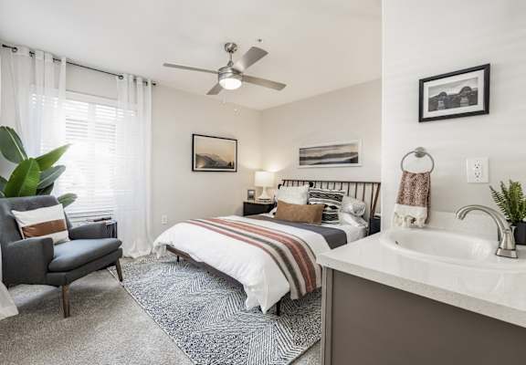 a bedroom with a bed and a ceiling fan