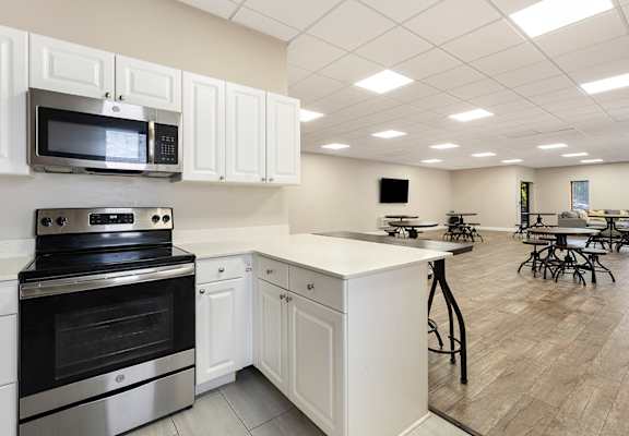 A kitchen with white cabinets and a black stove top oven.