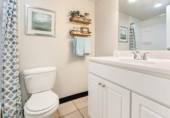 A white toilet sits next to a white sink in a bathroom.