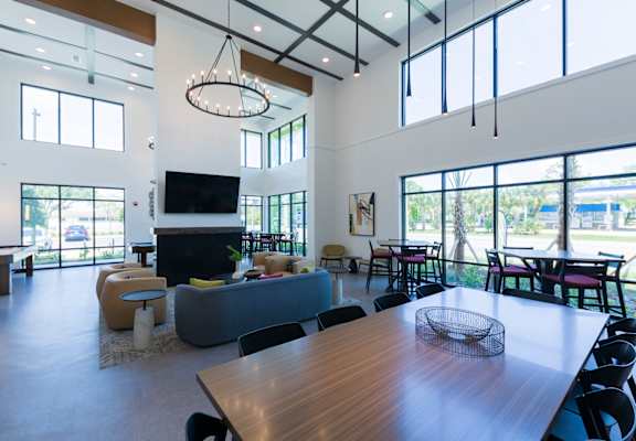 a large living room with large windows and a table and chairs