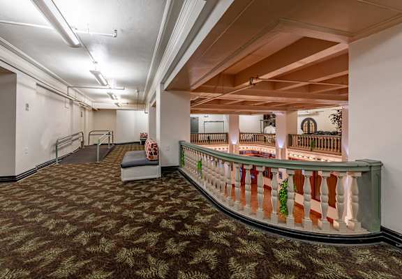 A long hallway with a bench and a railing.