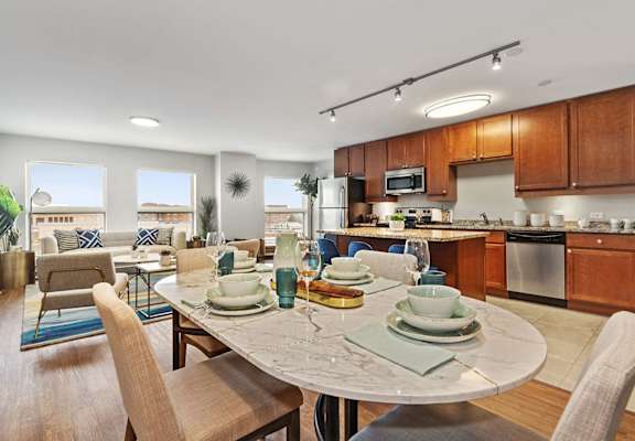 A modern kitchen with a dining table set for two.