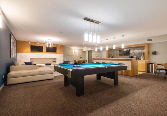 A room with a pool table and a couch.