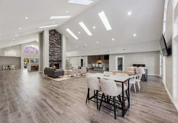 a large living room with a table and chairs and a fireplace