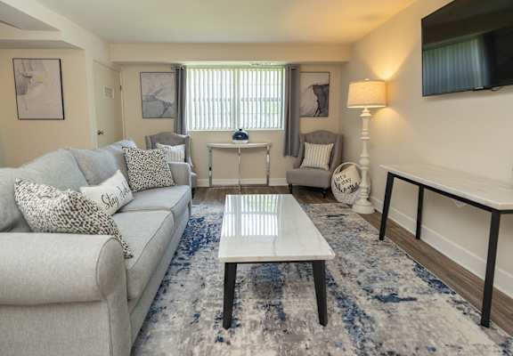 A living room with a grey couch and a white coffee table.