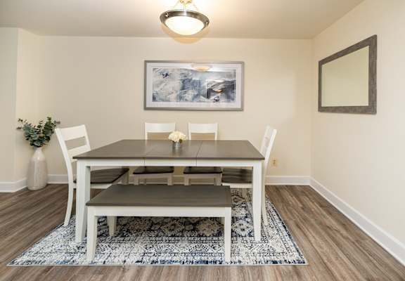 A dining room with a table and chairs.