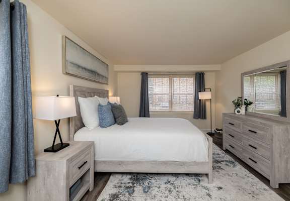 A bedroom with a large bed, nightstands, and a rug.